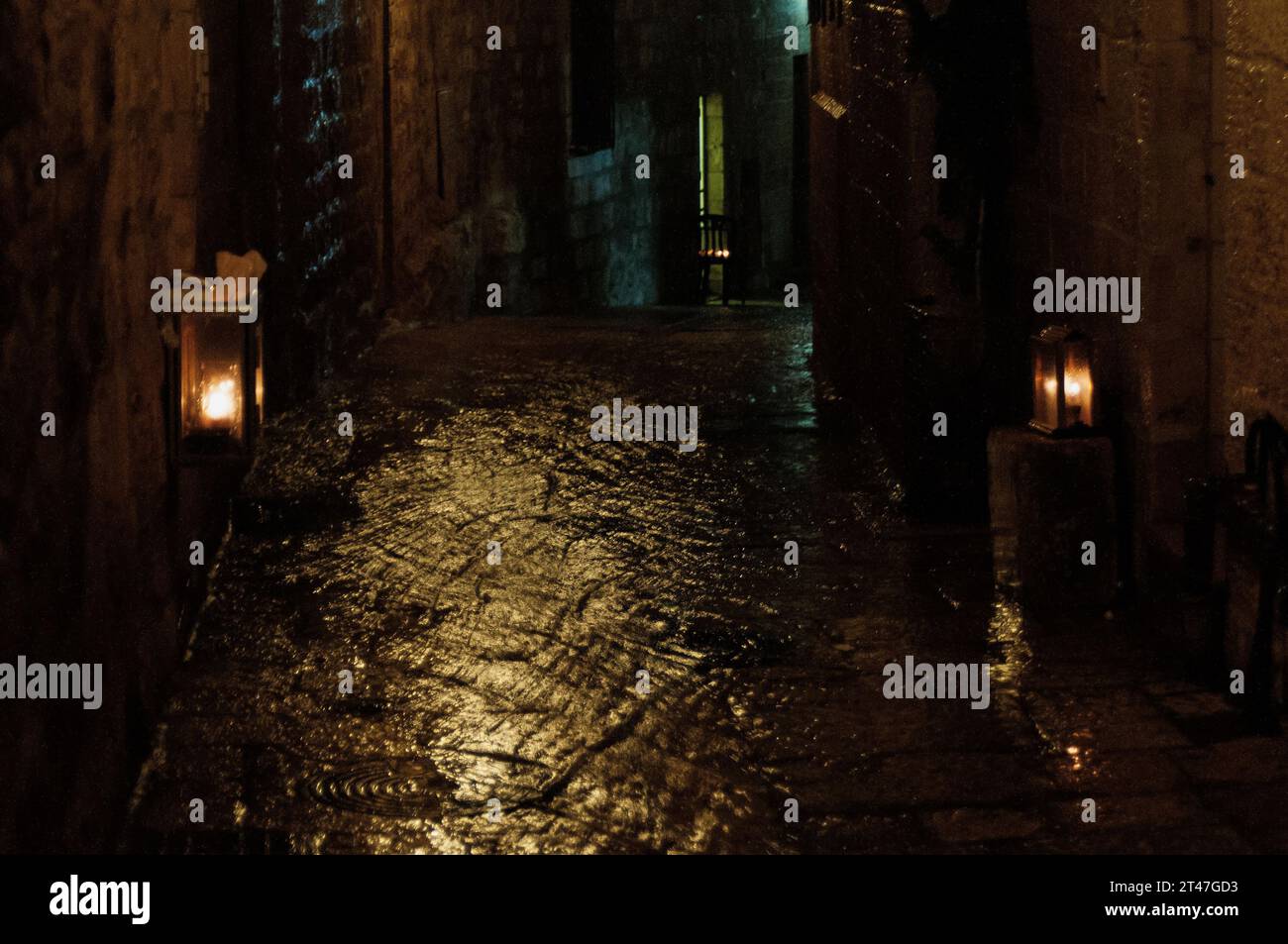 Hanukkah menorahs glow on a rainy winter night in the Old City of