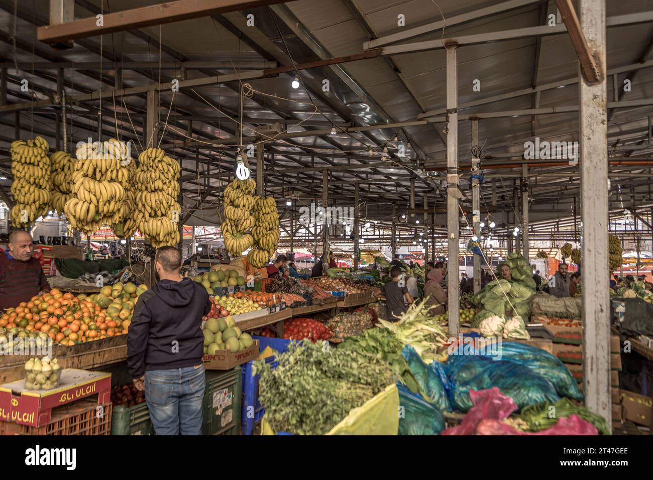 The people at food market with bananas, tomatoes, and other fruits and vegetables, at bazaar of Ramallah, the capital of Palestinian West Bank. Stock Photo