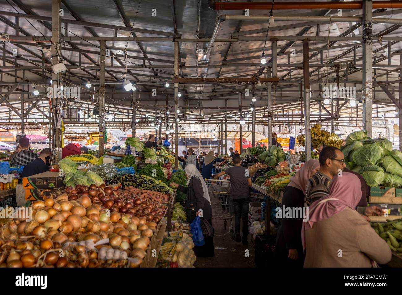 The people at food market with bananas, tomatoes, and other fruits and vegetables, at bazaar of Ramallah, the capital of Palestinian West Bank. Stock Photo