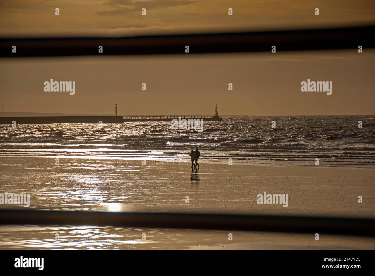 Swansea, UK. 29th Oct, 2023. A couple stroll along the waters edge in