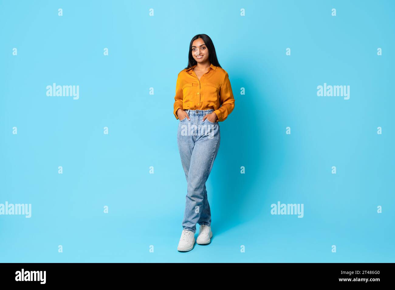 Indian lady standing full length with hands in pockets, studio Stock Photo