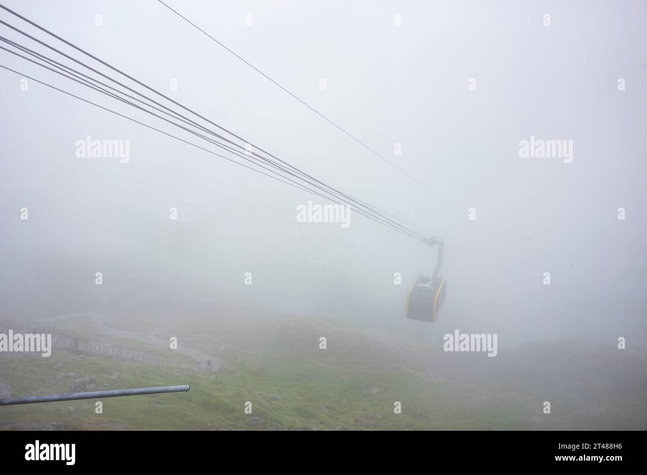 The Ulriken Cable Car brings tourists to the peak during a foggy ...