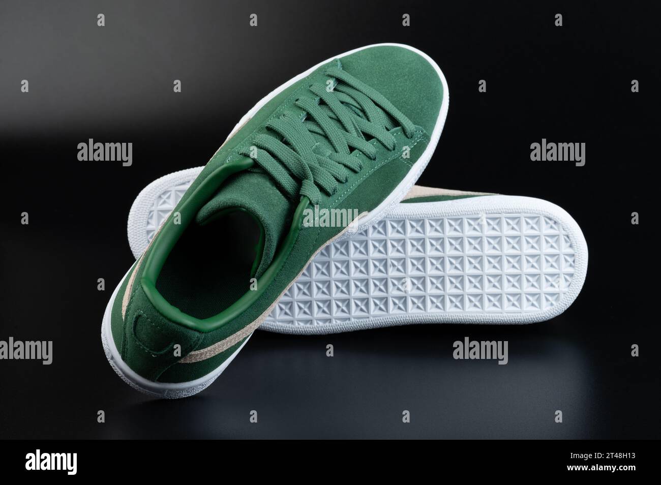 Pair of green casual shoes with white sole isolated on black background Stock Photo