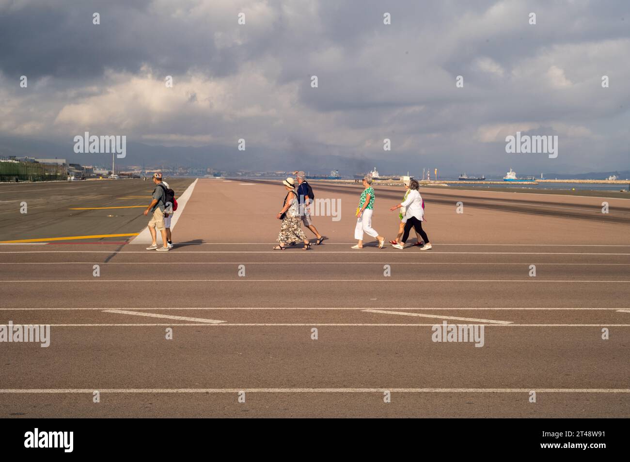 Gibraltar Airport runway and Winston Churchill Avenue with travellers walking or cycling through
