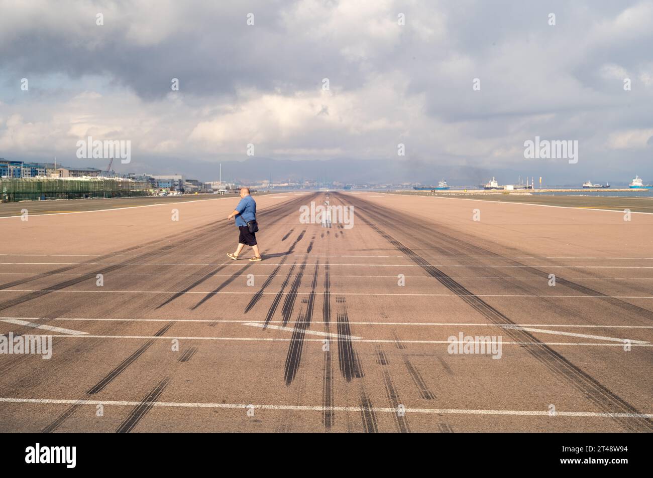 Gibraltar Airport runway and Winston Churchill Avenue with travellers walking or cycling through