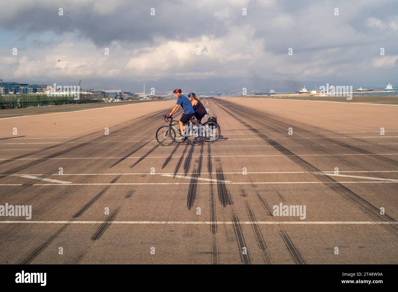 Gibraltar Airport runway and Winston Churchill Avenue with travellers walking or cycling through