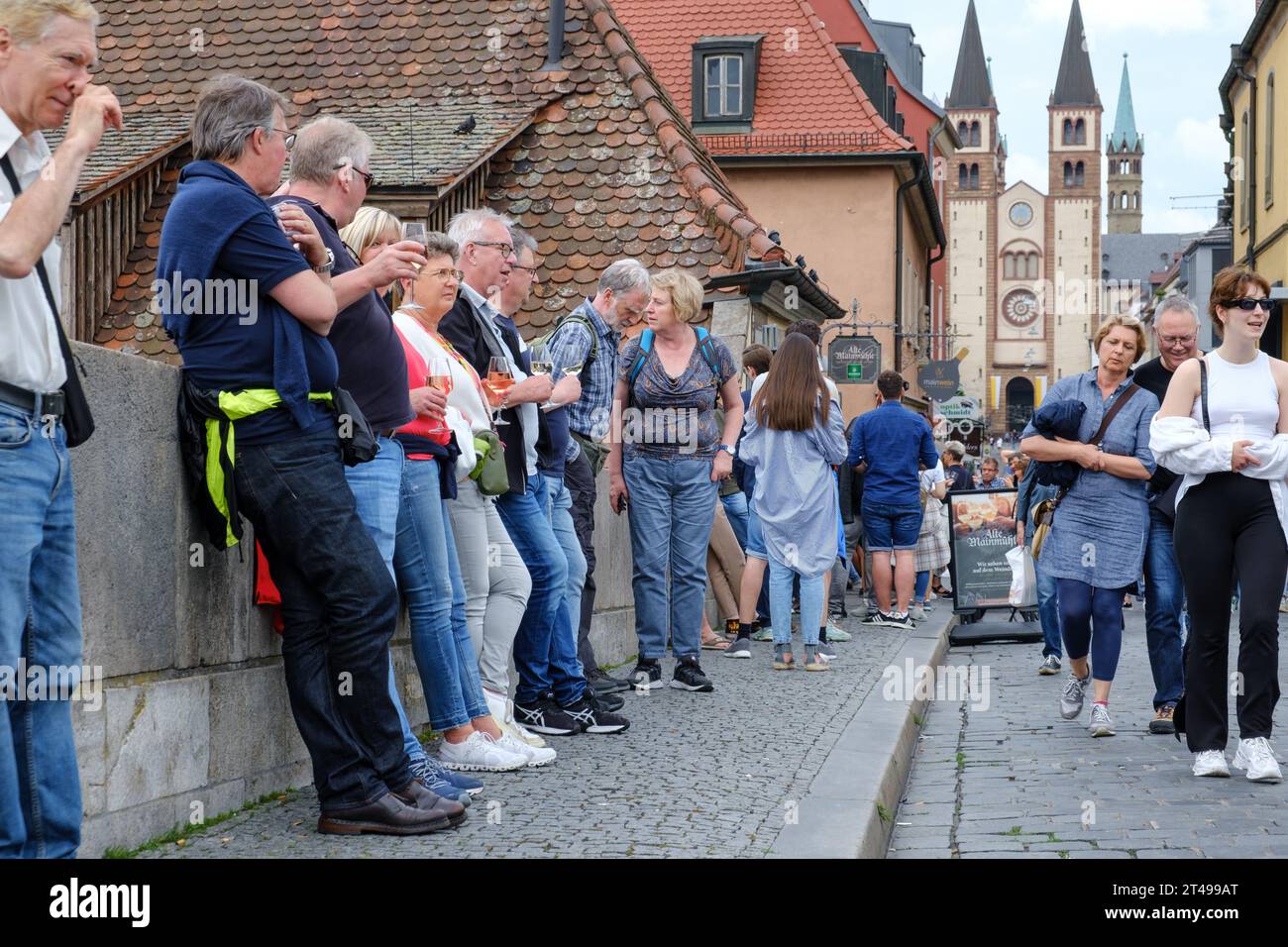 View of various visitors drinking wine at the Bridge alte Mainbrücke in Würzburg. Stock Photo