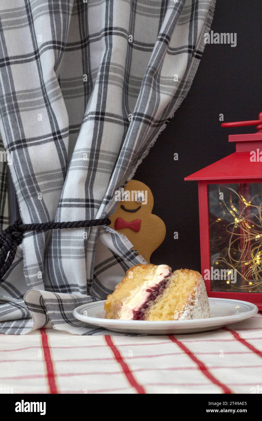Joyful gingerbread person eyeing a piece of cream cake with intense glee Stock Photo
