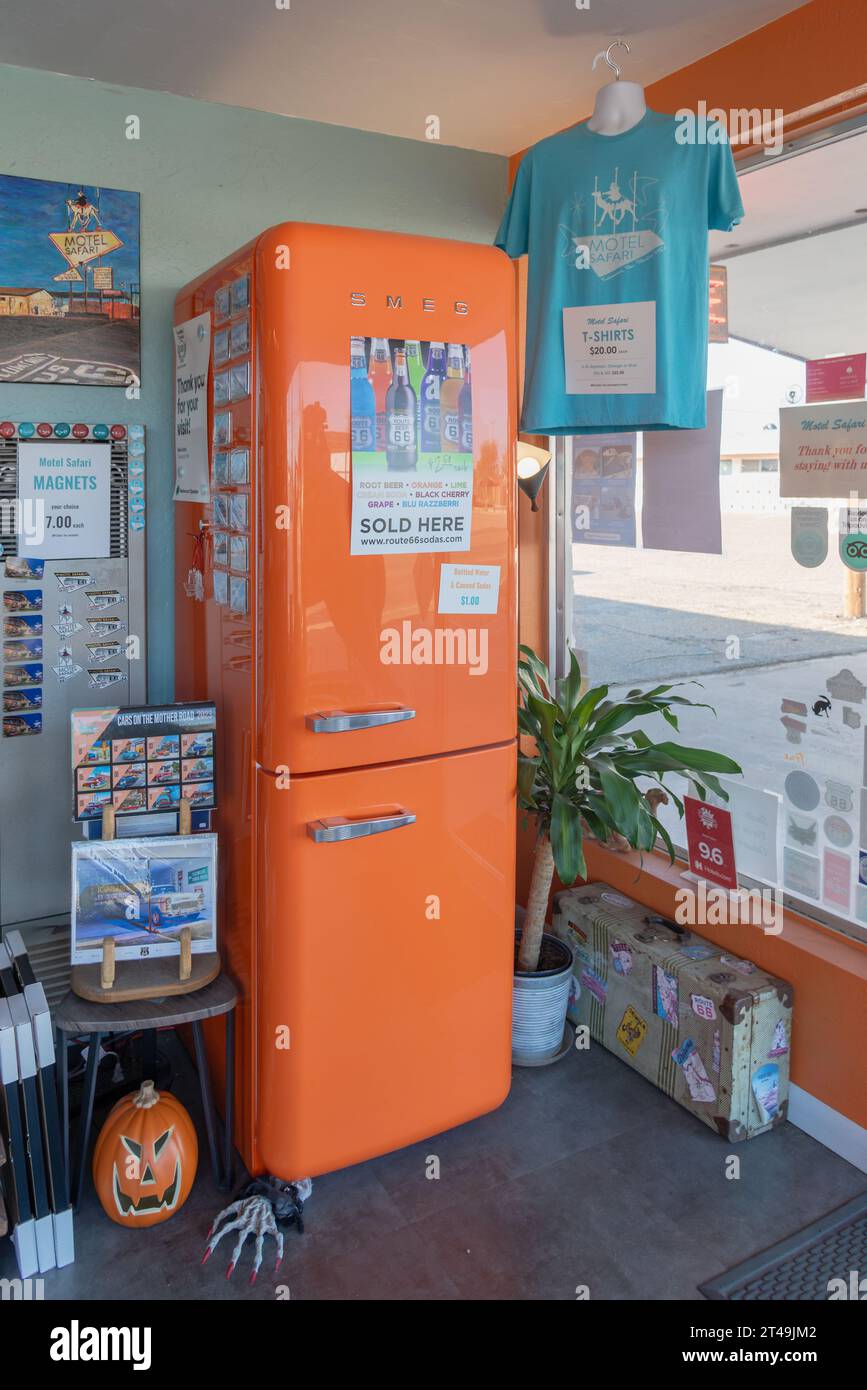 An orange retro style Smeg refrigerator in the lobby of the Motel Safari that is filled with trinkets and souvenirs, Tucumcari, New Mexico, USA. Stock Photo