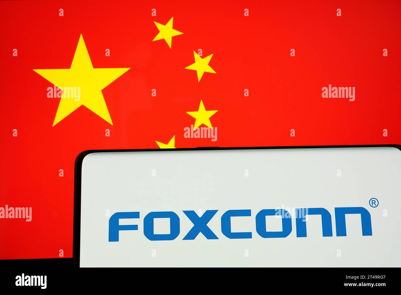 Iphone manufacturer  FOXCONN logo on smartphone and blurred flag of China at the background screen. Concept. Stafford, United Kingdom, October 29, 202 Stock Photo