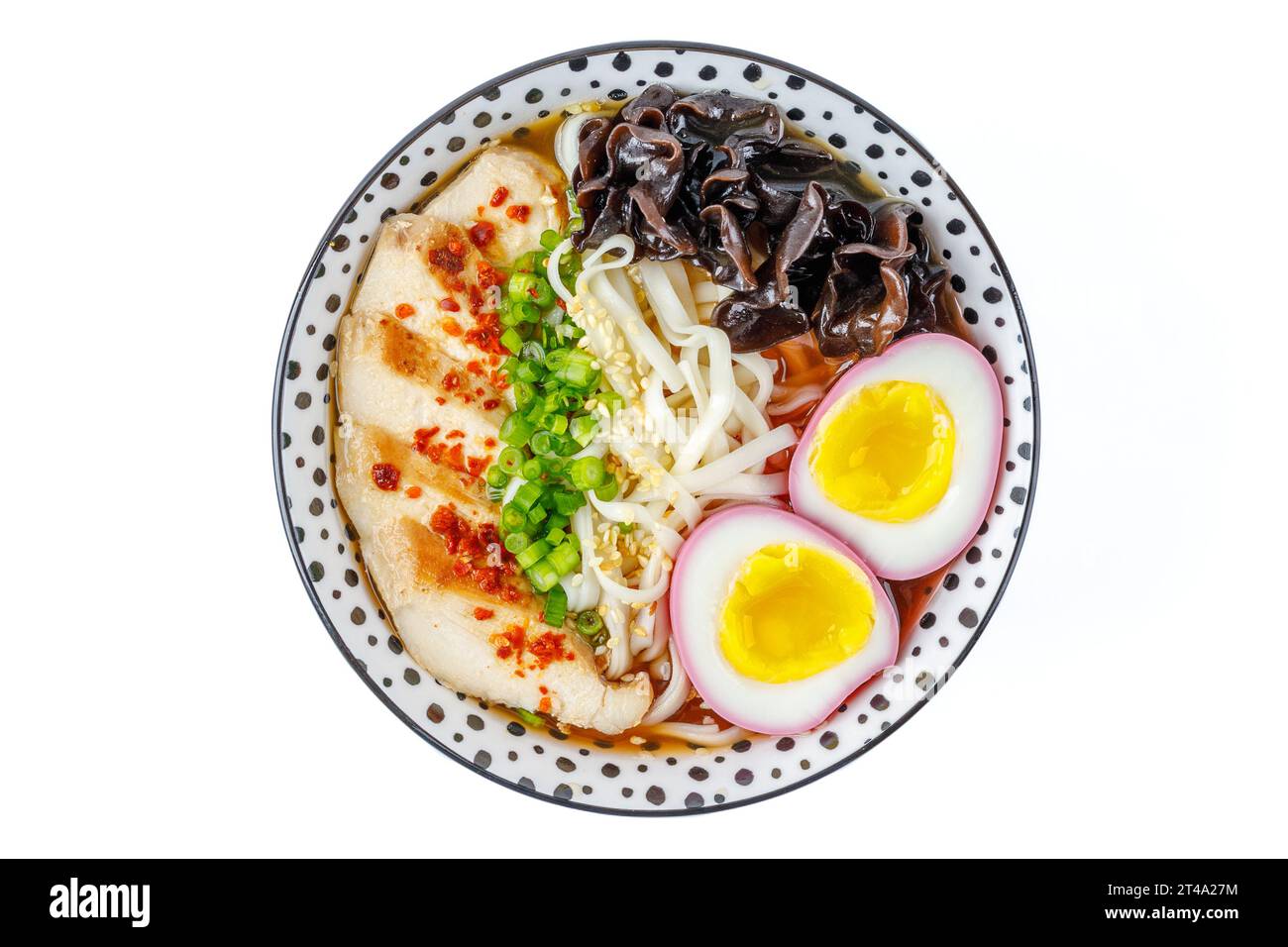 Chicken miso ramen with chicken marinated egg and beet juice on a white