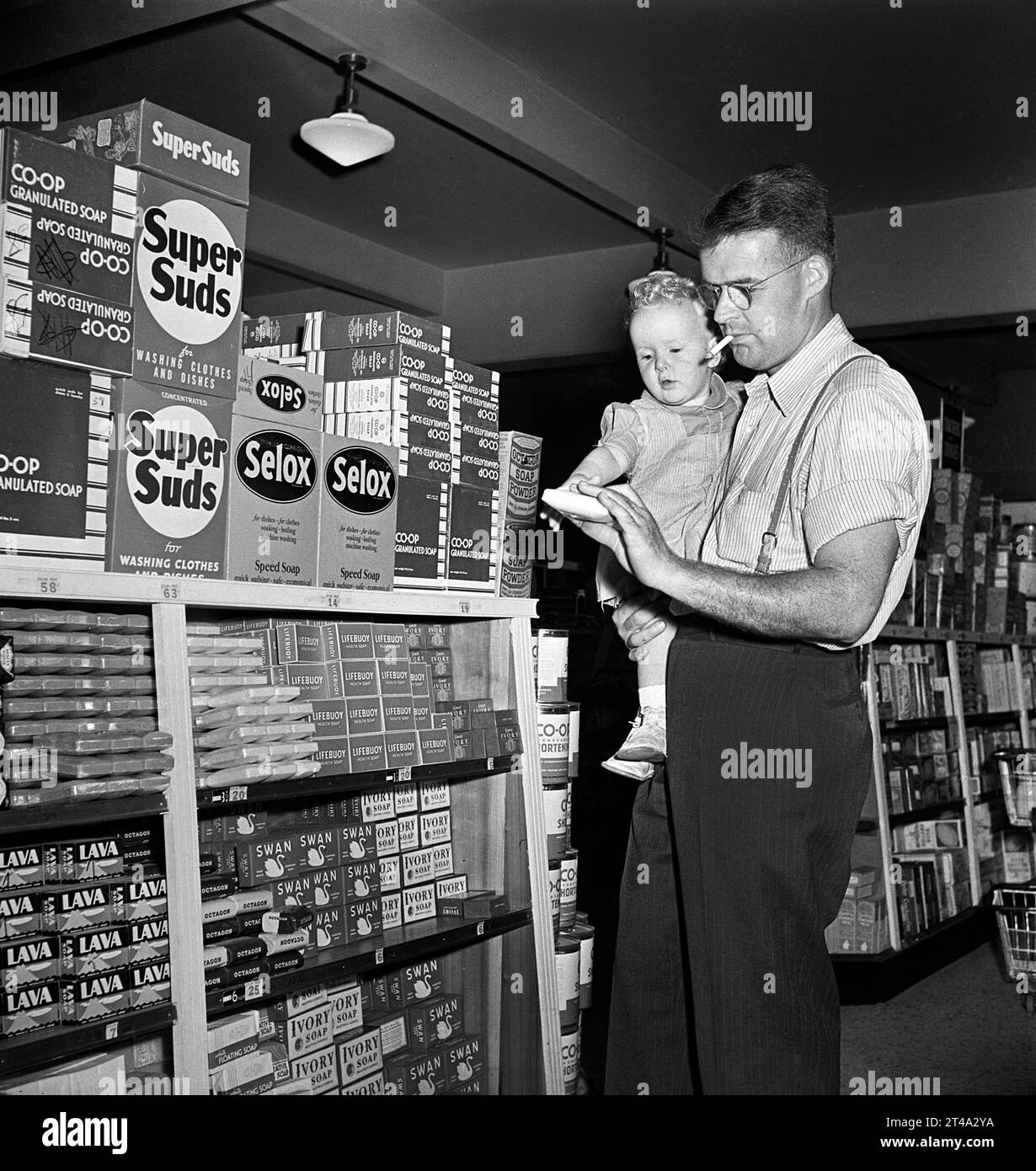 Father with infant son shopping in cooperative grocery store, Greenbelt, Maryland, USA, Marjory Collins, U.S. Office of War Information, June 1942 Stock Photo