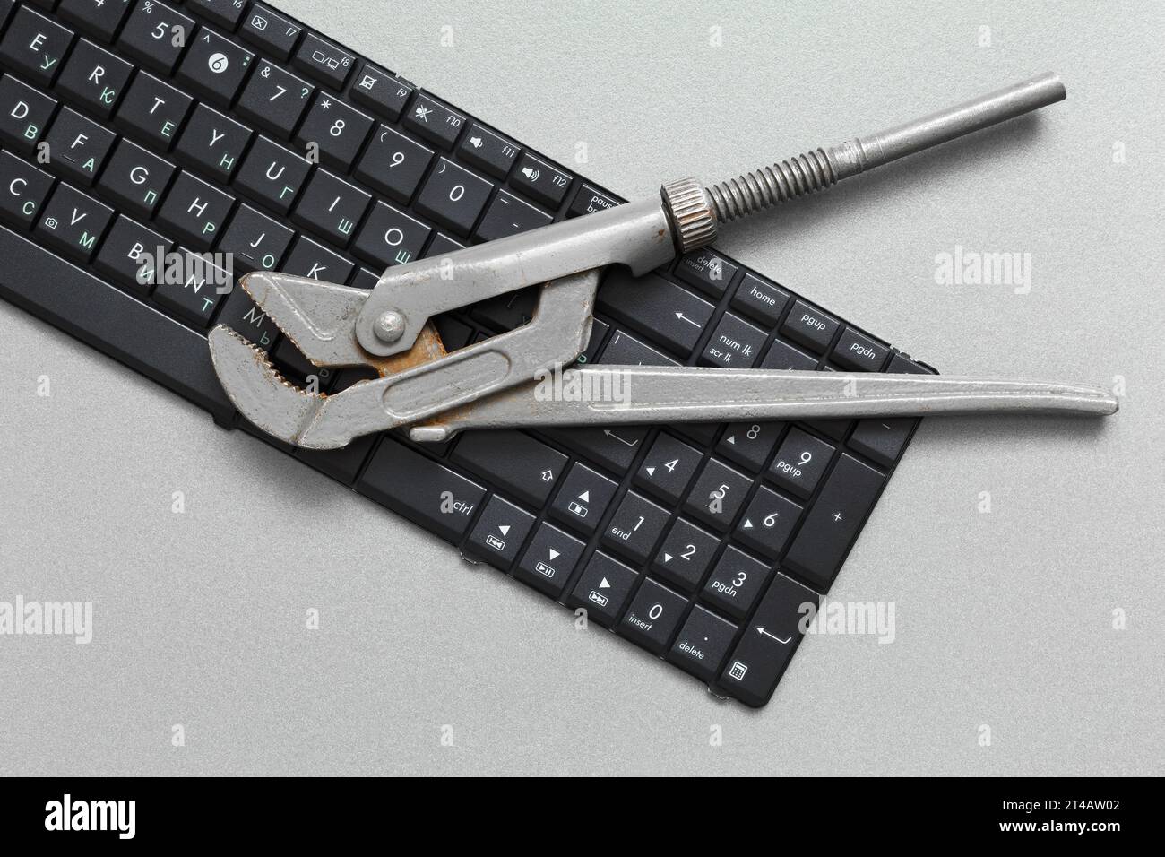 The adjustable wrench is on the keyboard. Concept for maintenance and repair of computer equipment. Stock Photo