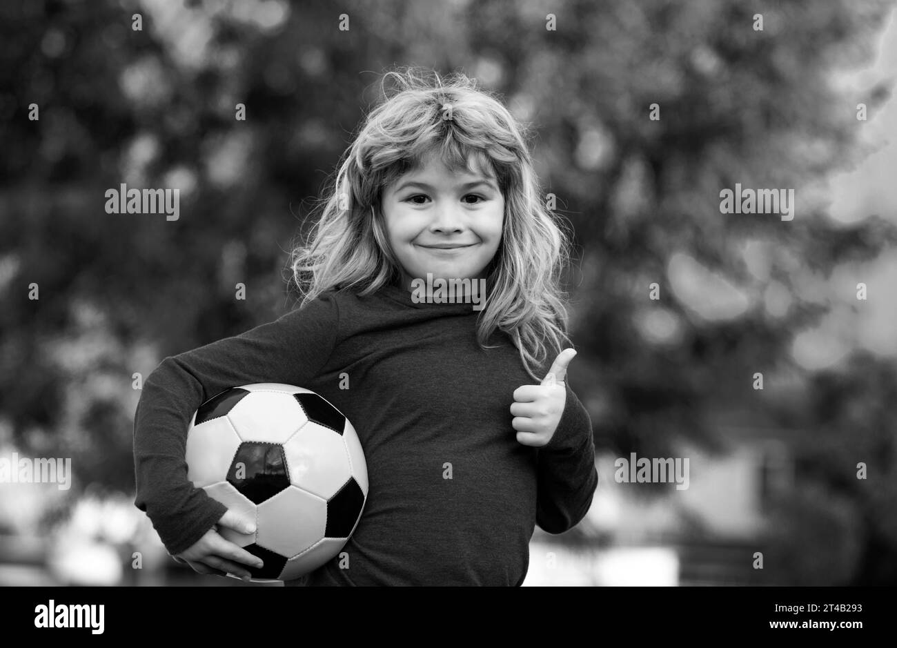 Boy child playing football on football field. Kid playing soccer show