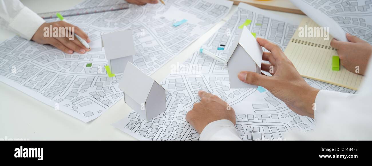 Worker, architect and engineer work on real estate construction project oratory planning with cartography and cadastral map of urban town area to Stock Photo