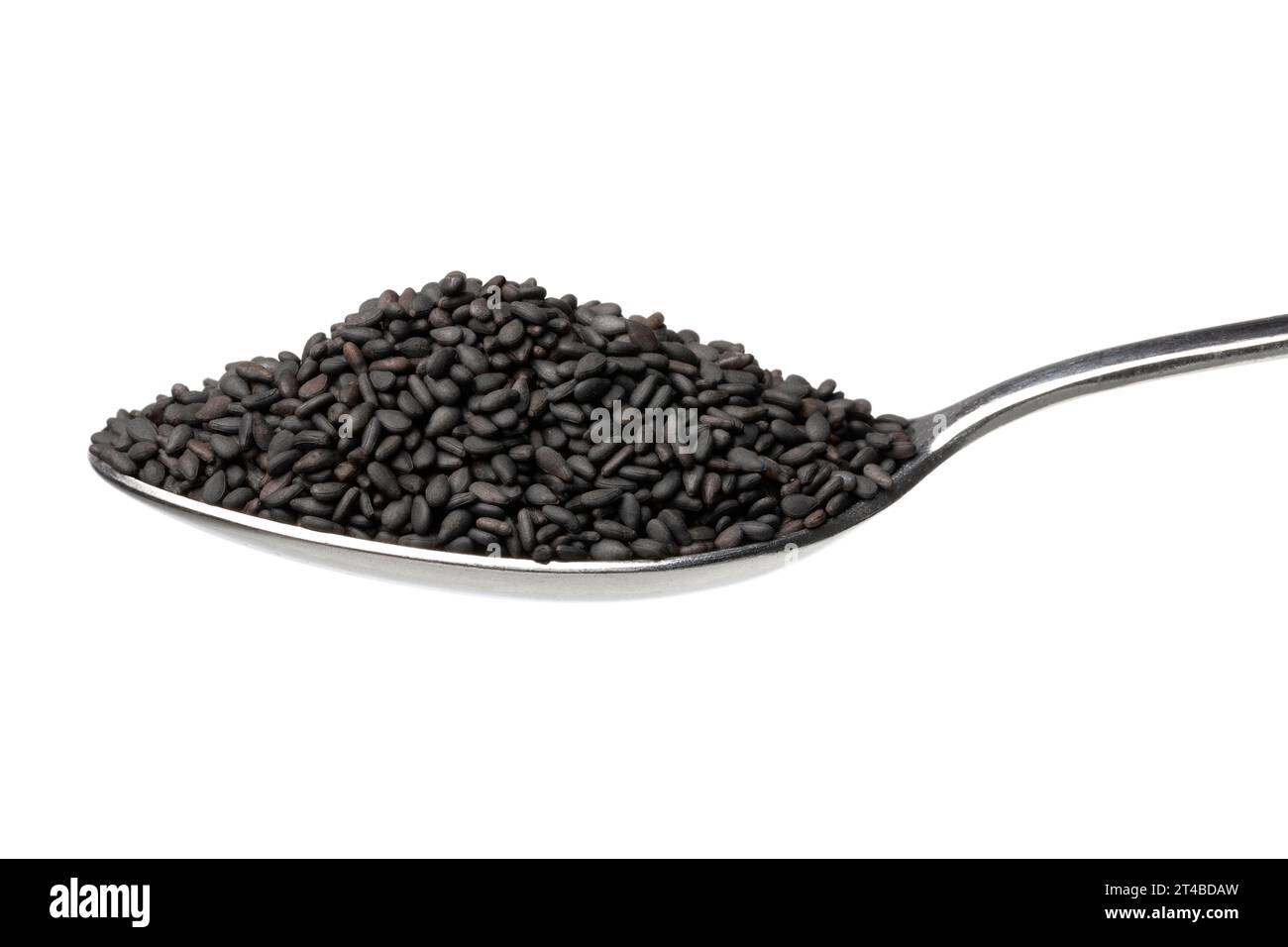 Single metal spoon with roasted black sesame seed on white background close up Stock Photo