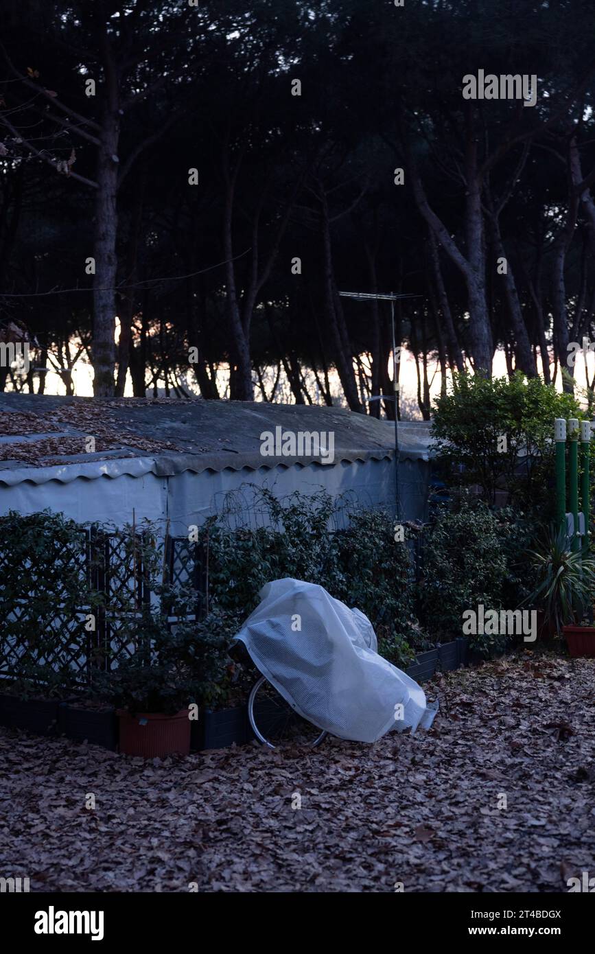 Rusty bicycles covered with a tarpaulin at an out-of-season campsite, Tuscany, Italy Stock Photo