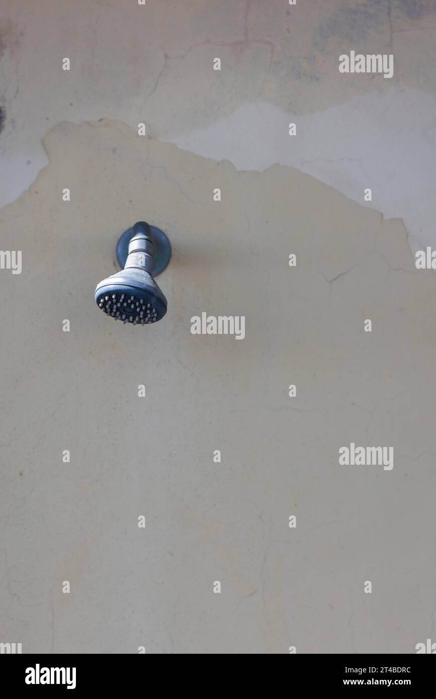 Shower on a weathered wall on the beach, Bari Sardo, Ogliastra, Sardinia, Italy Stock Photo