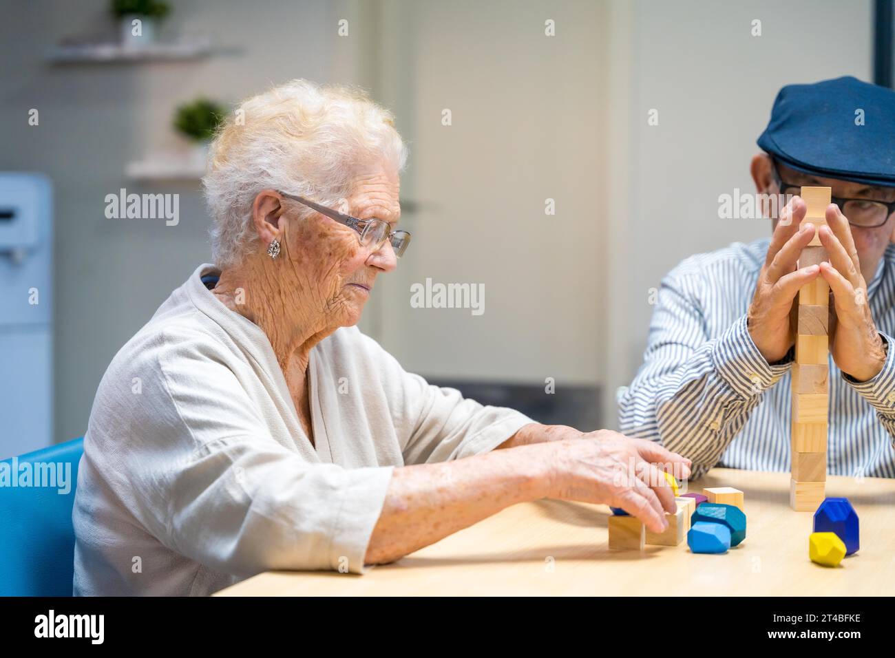 Old woman and man in a nursing home playing skill games Stock Photo