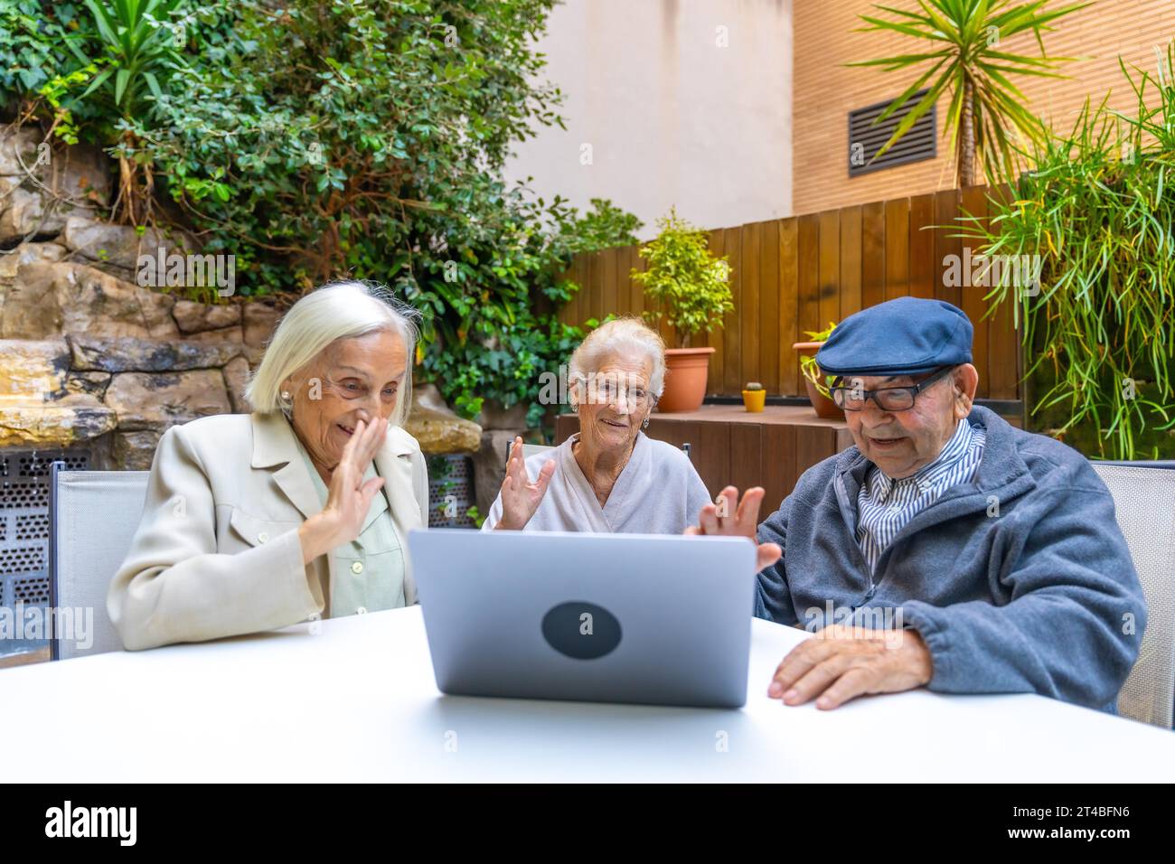 Introducing technology to senior people in a nursing home while three people using laptop Stock Photo