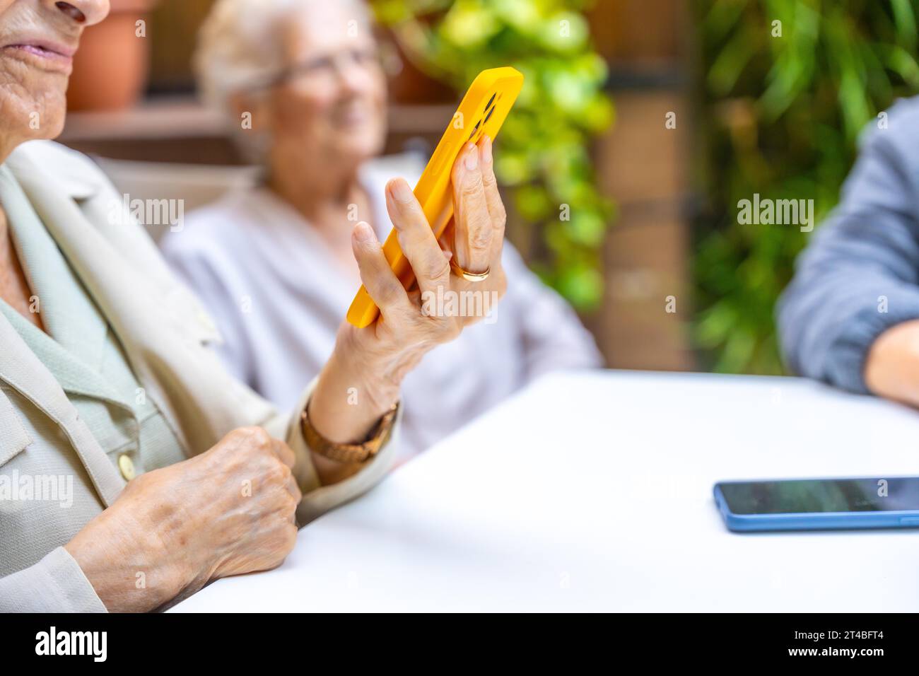 Close-up of elder woman using phone to listening to music in a geriatric Stock Photo