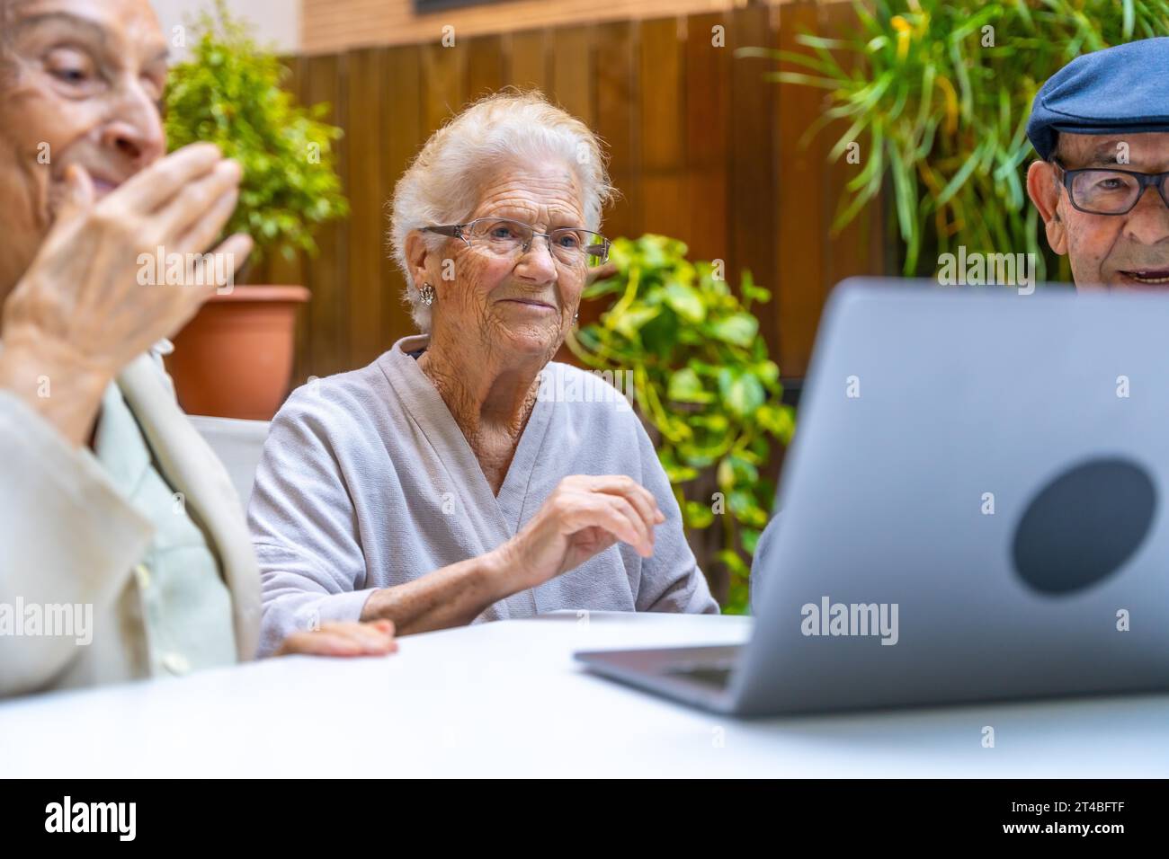 Cute senior people learning how to use a laptop in a geriatric Stock Photo