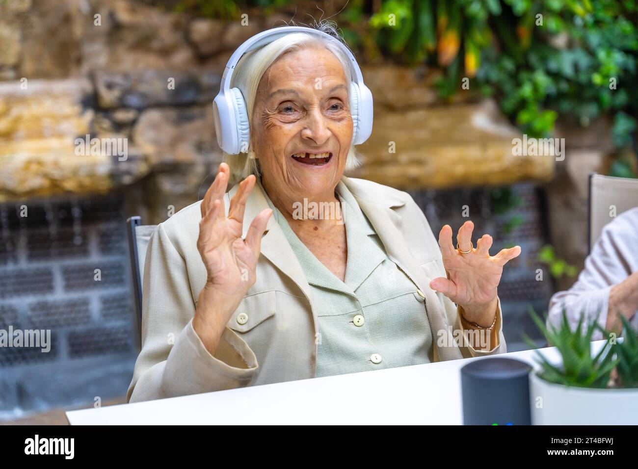 Happy woman using new technology to listening music in a geriatric Stock Photo
