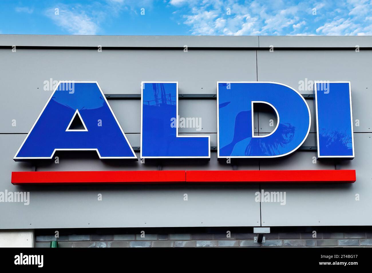 Logo lettering Aldi in blue with red underline on wall of supermarket