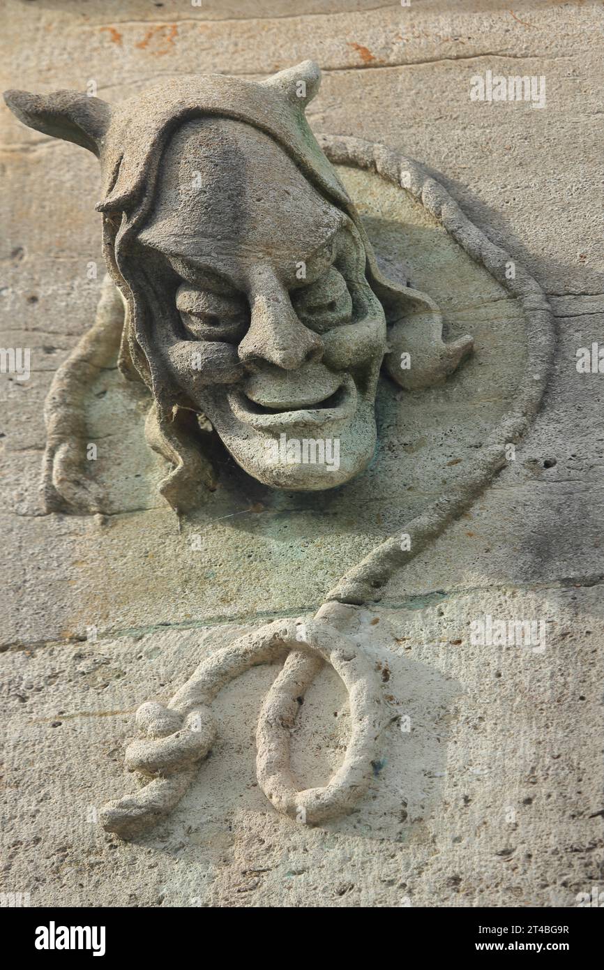 Relief of the executioner at the hangman's house, historical, sculpture, devil, face, head, detail, ugly, grin, grimace, rope, noose, horns, stone Stock Photo