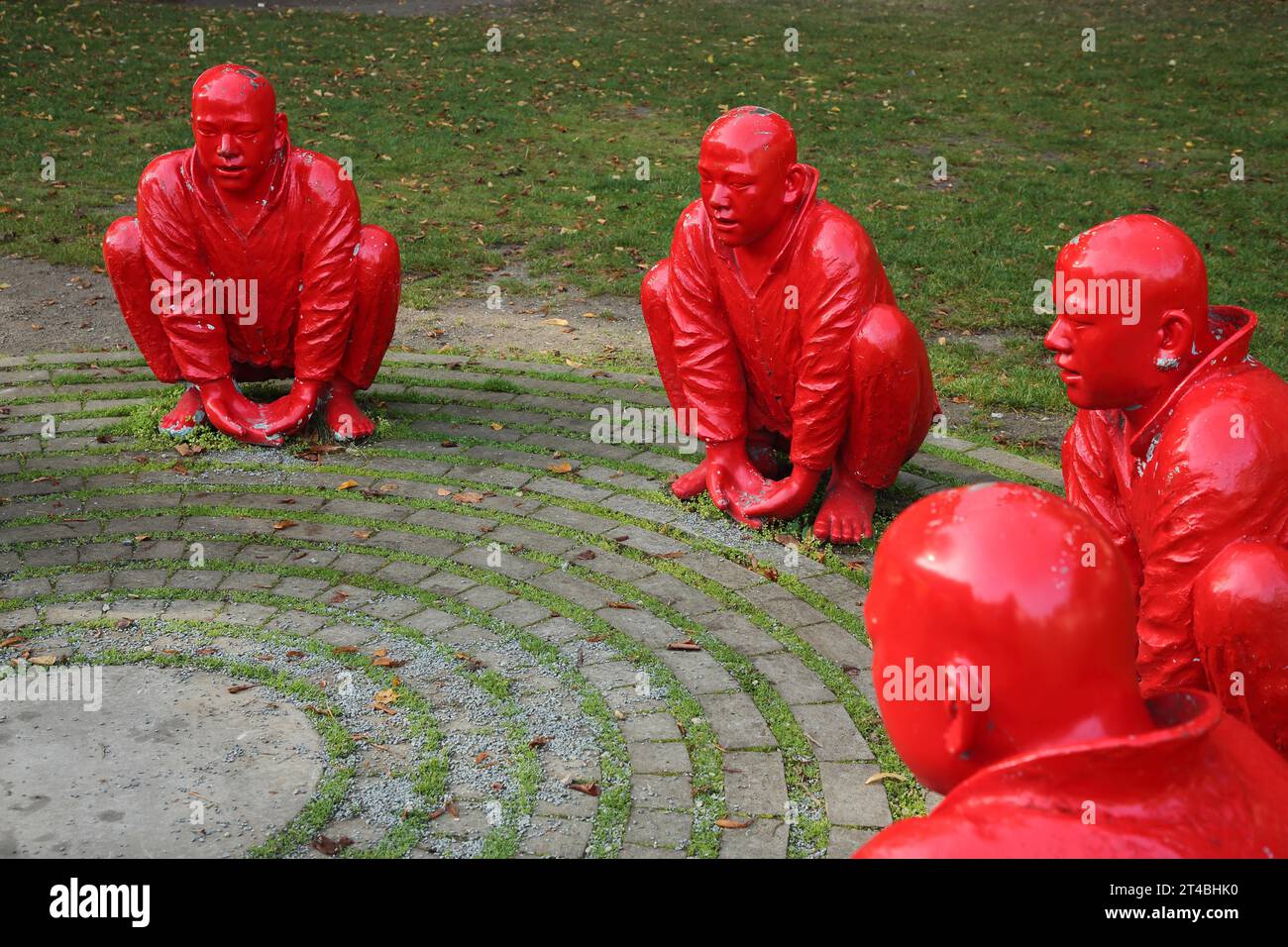 Sculpture Meeting by Wang Shugang 2013, sculpture group, red, figures, circle, sitting, men, Chinese, Chinese monks, kneeling, heads, back Stock Photo