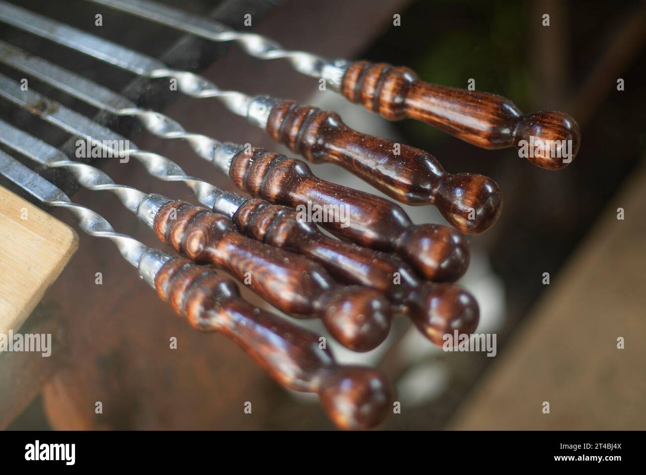 Meat skewers. Kitchen details. Steel skewer with wooden handle. Meat Cooking Accessories in Detail. Stock Photo