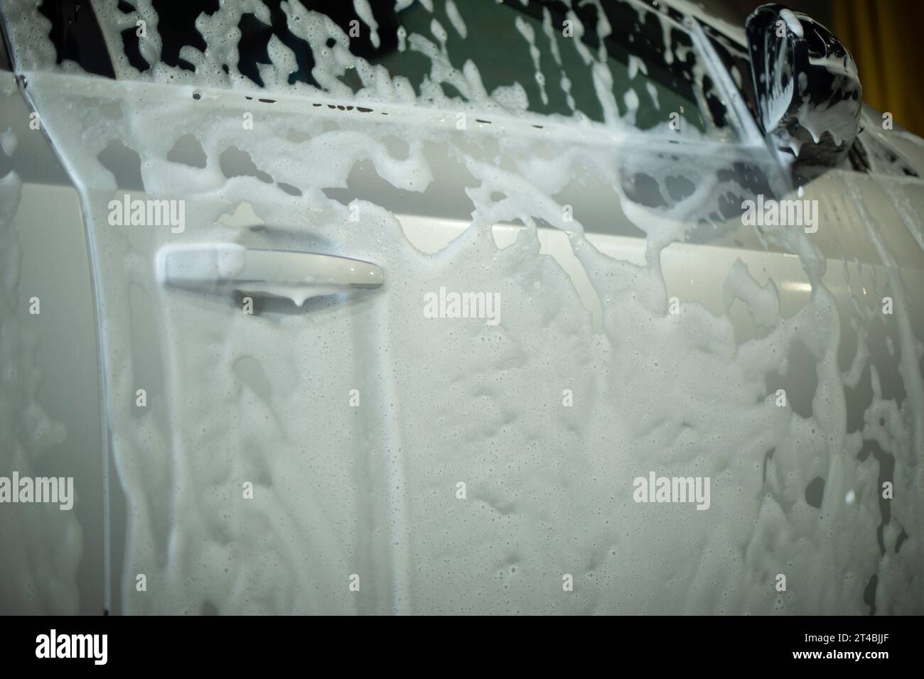 Soap foam on the car door. Car Wash in Detail. Washing off the dirt