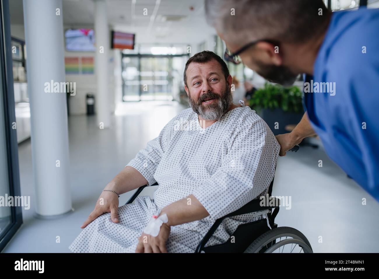 Supportive nurse soothing a worried patient in wheelchair. Illnesses and diseases in middleaged