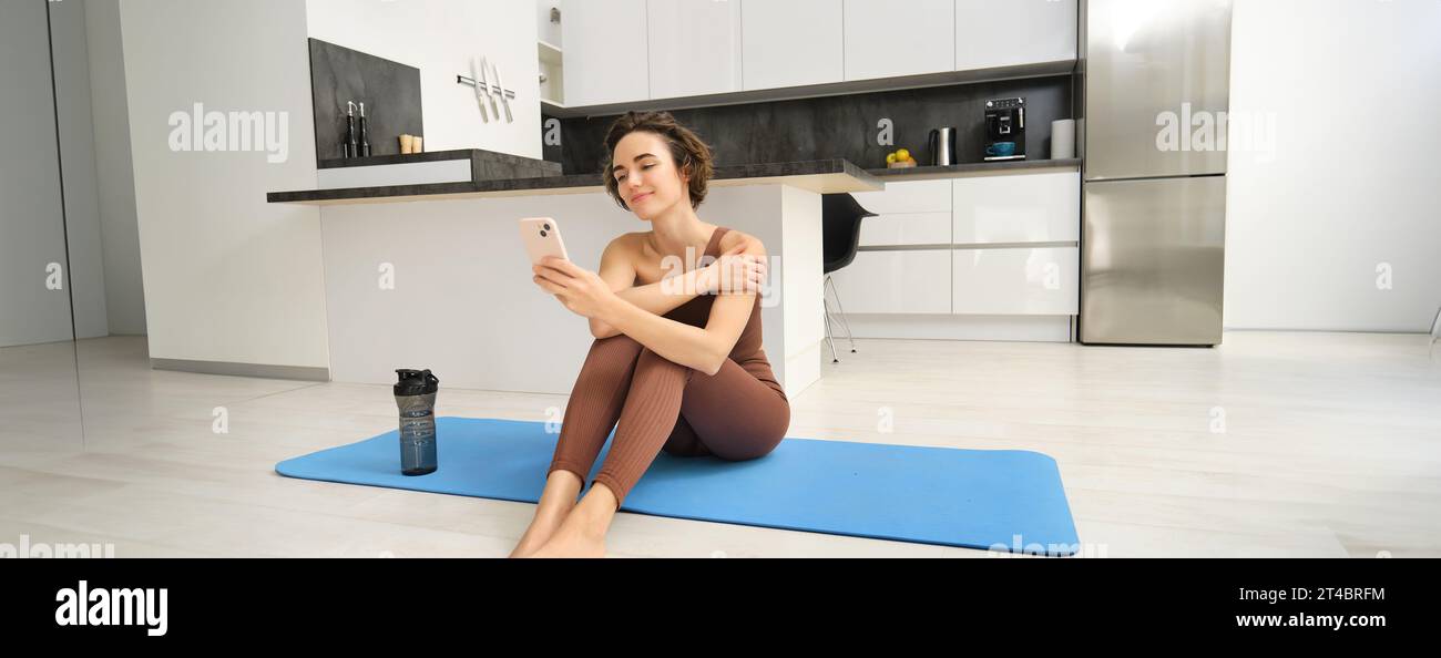 Active lifestyle and health. Happy young woman does workout, sits