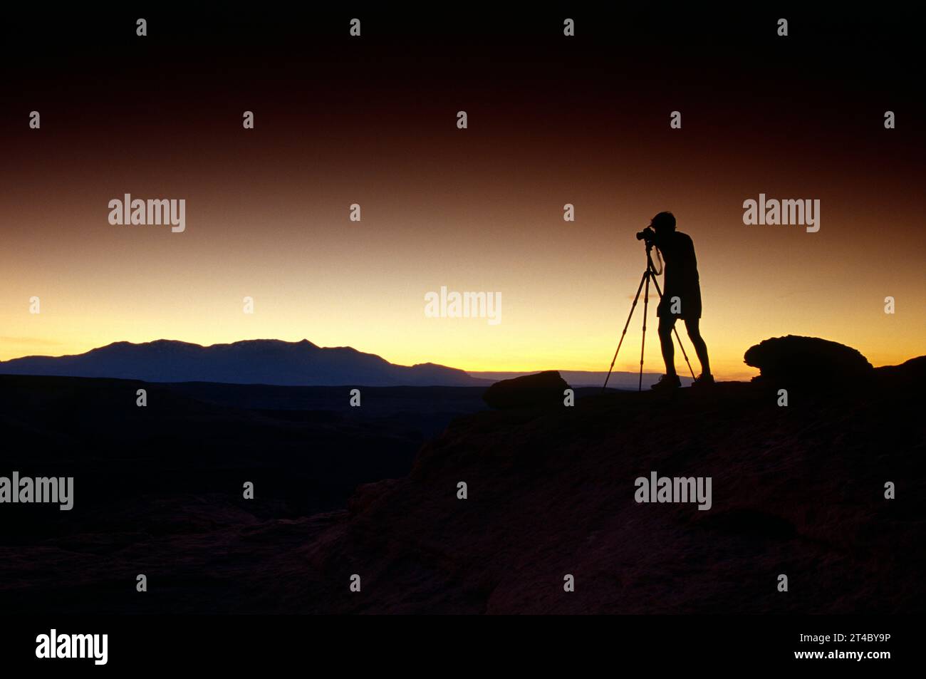 Silhouette of man and tripod taking pictures of sunset Stock Photo - Alamy