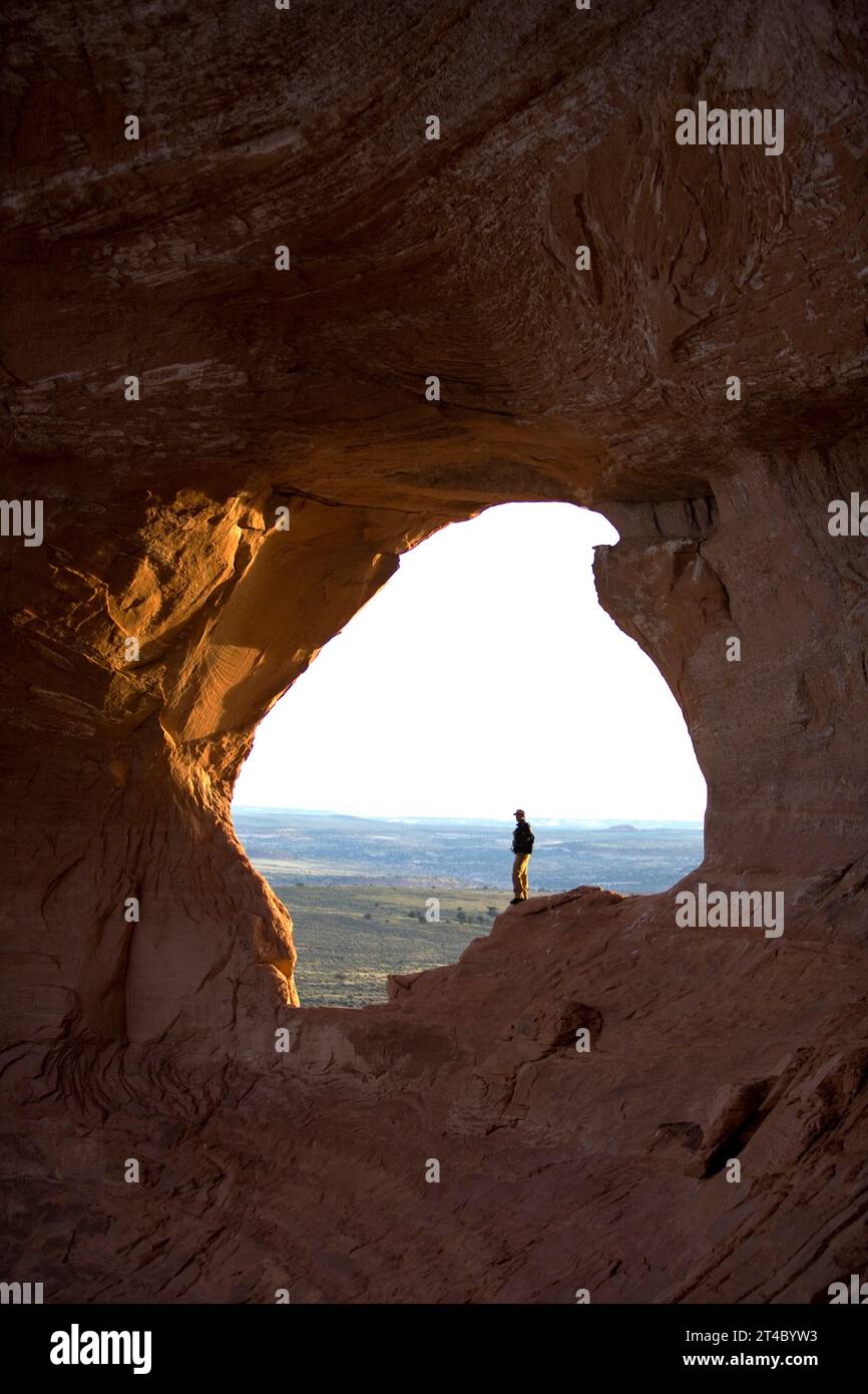 Man standing in Looking Glass Arch, Moab, Utah. Stock Photo