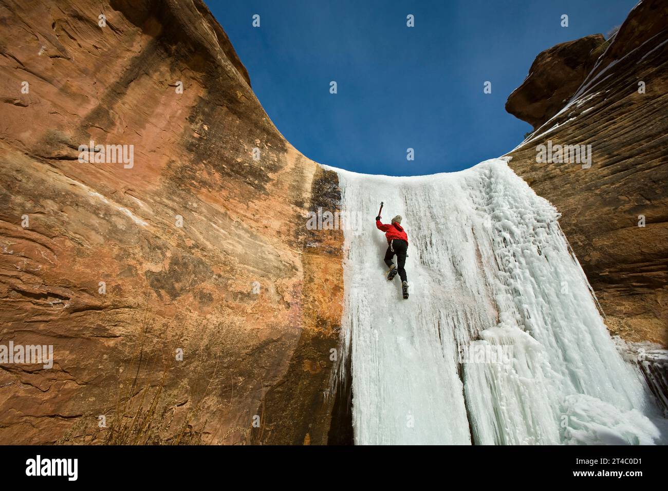 A man ice climbing a frozen waterfall in Utah. Stock Photo