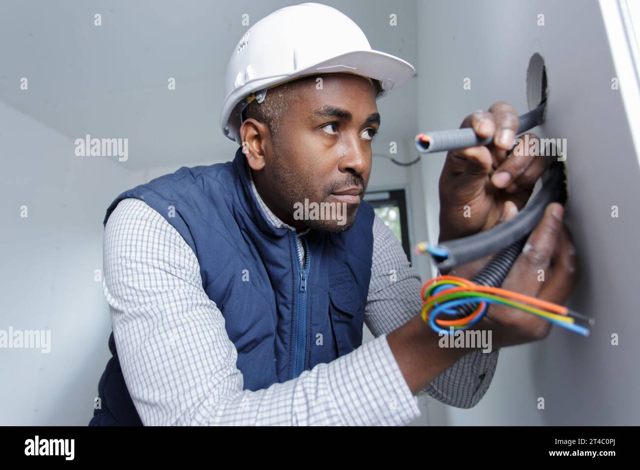 worker trying to install wires on the wall Stock Photo