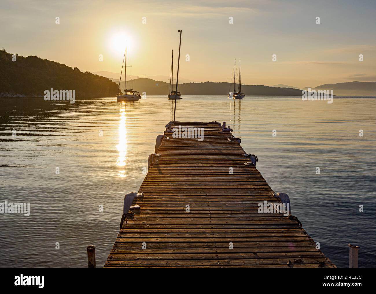 Dawn from a jetty in the little harbour of Agios Stafanos on the north east coast of Corfu in the Ionian Islands Greece Stock Photo