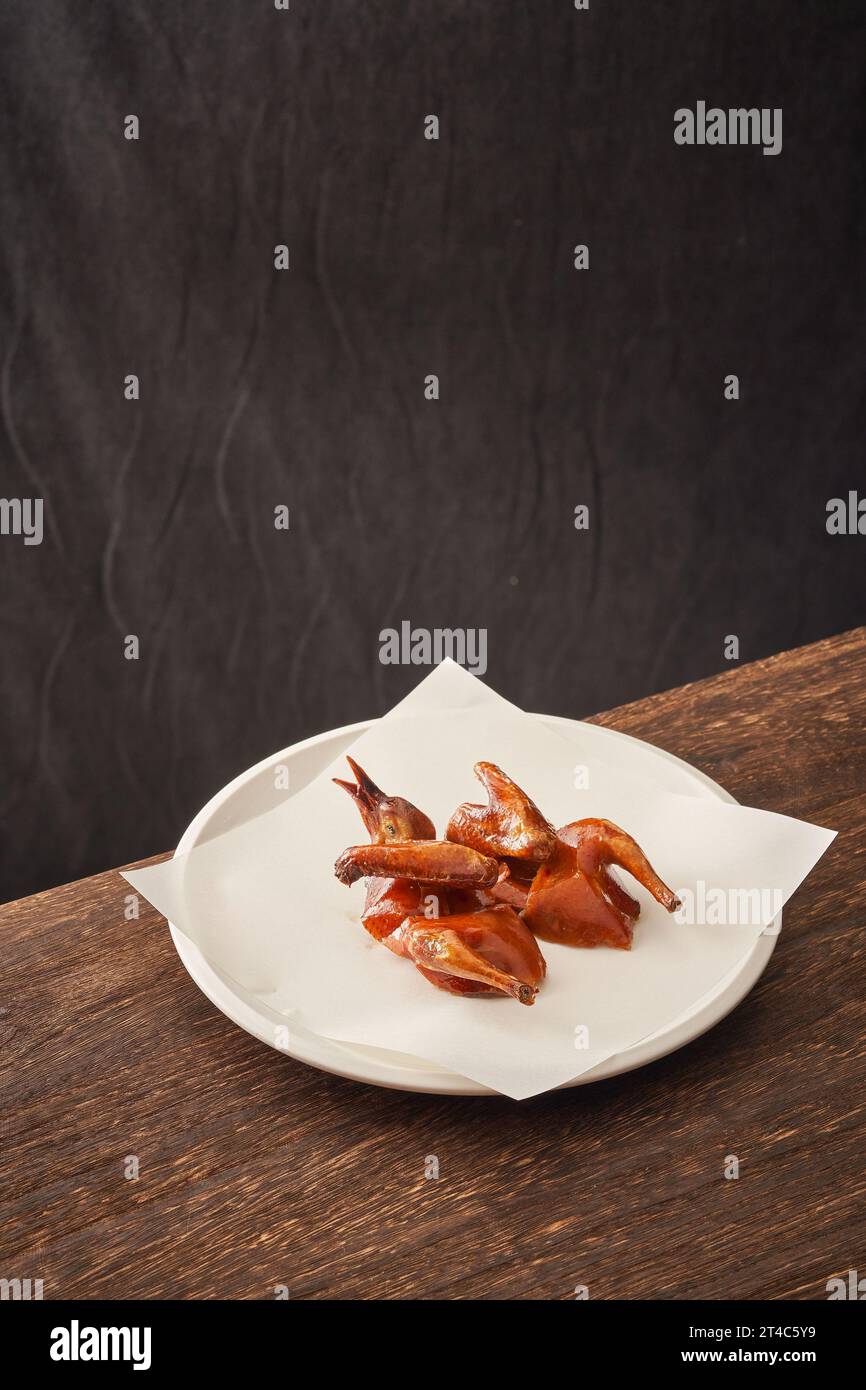 Traditional Cantonese grilled pigeon on a white porcelain plate，Crispy Pigeon Stock Photo