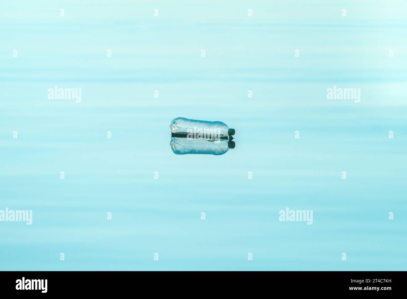 Empty plastic bottle floating on water, environmental damage and