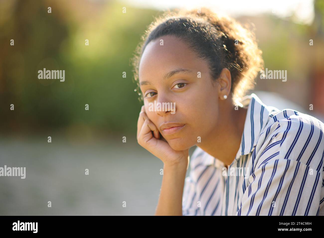 Portrait of a serious black woman posing in a park Stock Photo