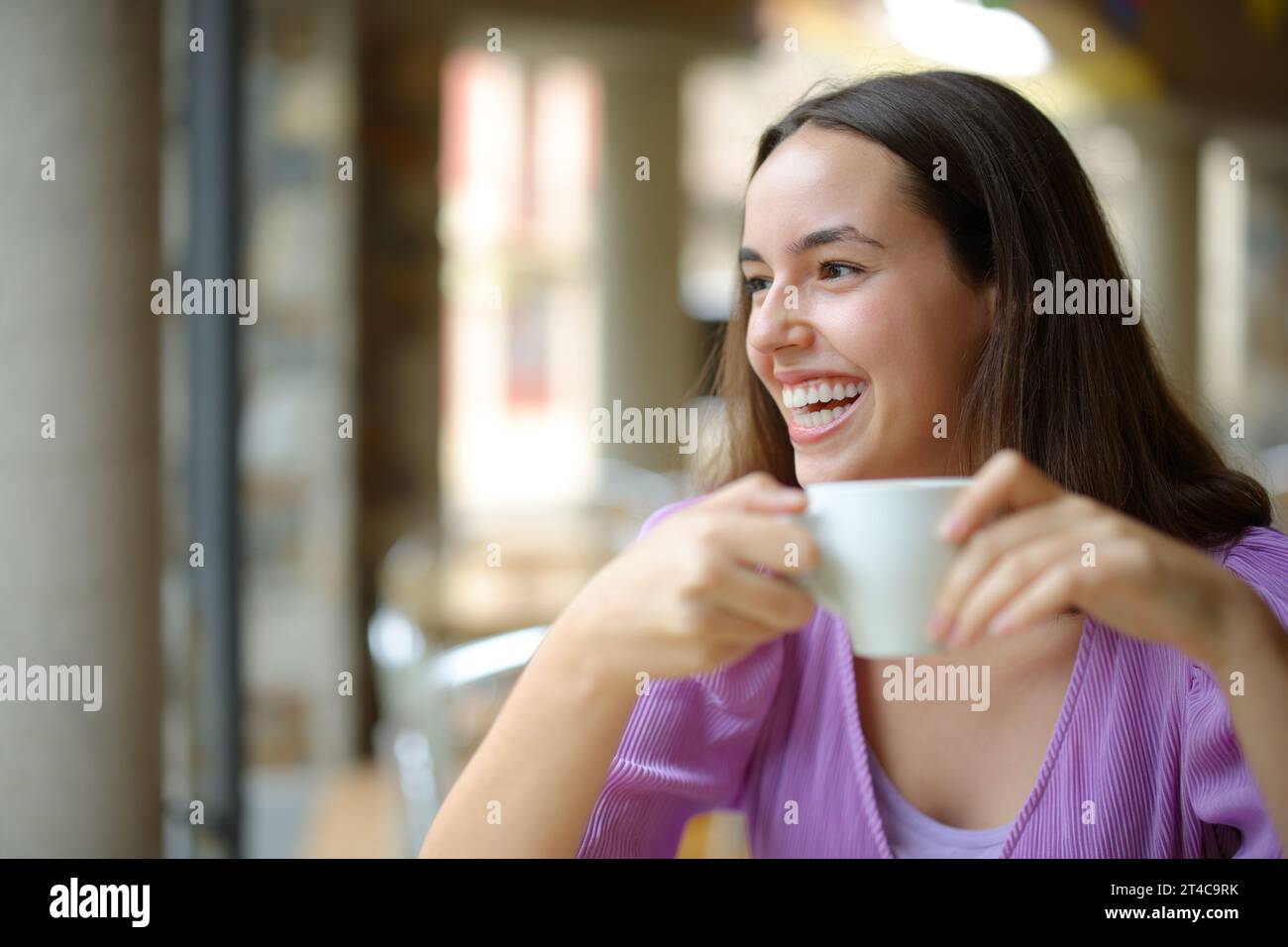 Happy woman at breakfast drinking coffee laughing looking at side Stock Photo