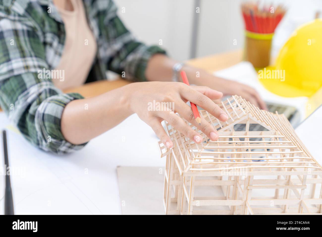 Architects working on a house model in a creative office. Stock Photo