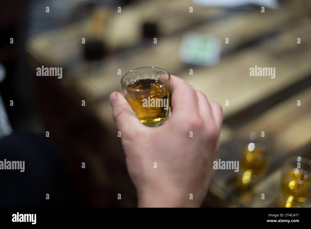 Strong alcohol. Stack of cognac. Hand holding stack of strong drink