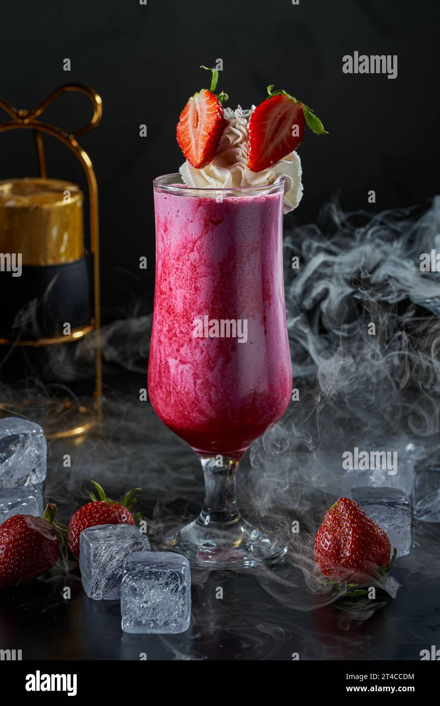 Image of a strawberry and milk cocktail glass with cream on a black ...