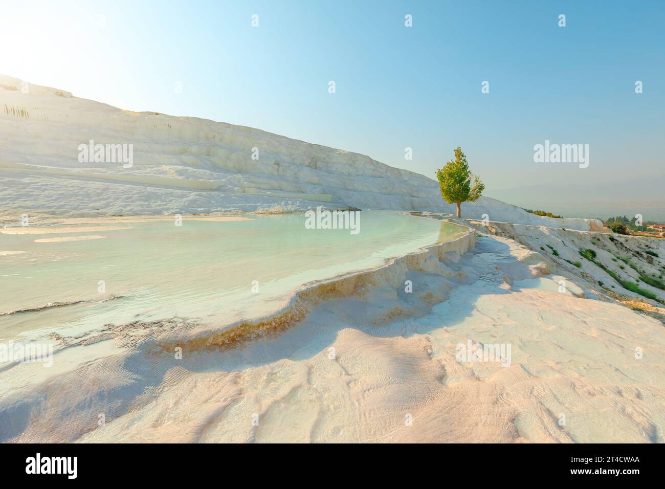 Pamukkale in Turkey reveals its breathtaking thermal pools. Adorned with radiant white terraces, crafted by the mineral-enriched thermal waters Stock Photo