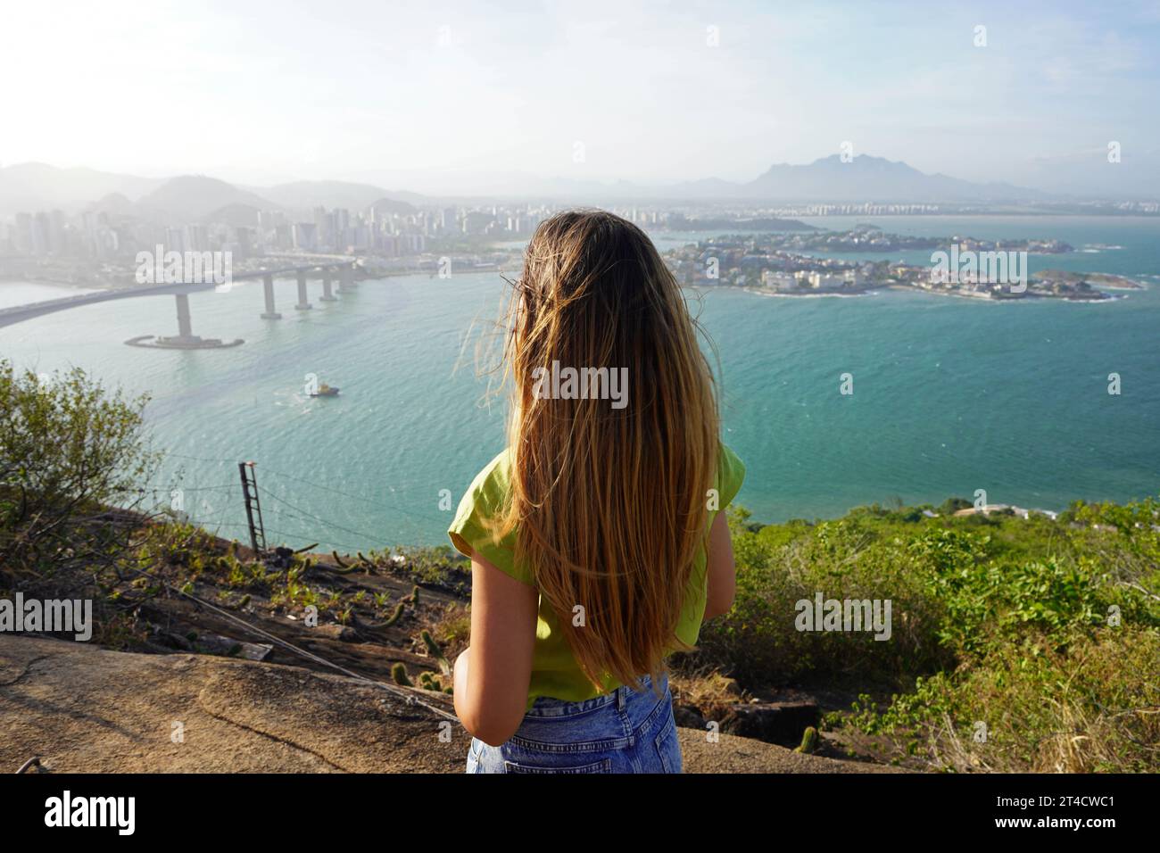 Back view of woman admiring the landscape from lookout top view at sunset. Peace and freedom concept. Stock Photo