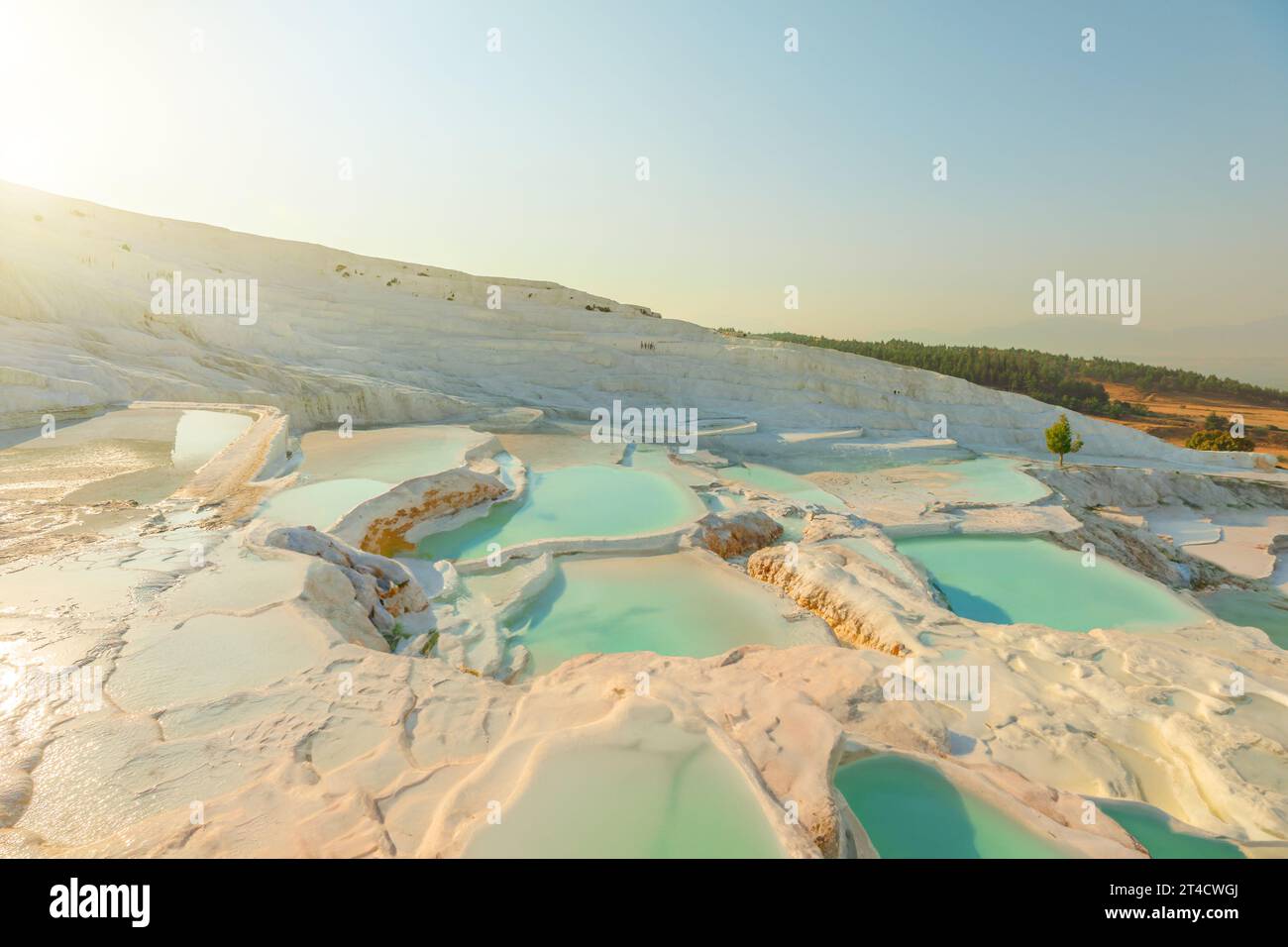 Pamukkale in Turkey, a UNESCO World Site, is famous for its stunning white terraces created by mineral-rich thermal waters that cascade down Stock Photo
