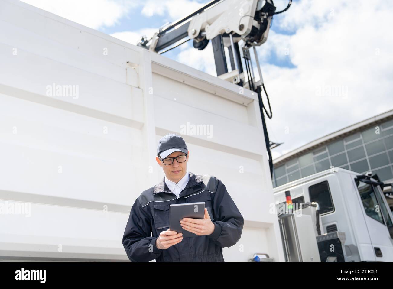 Manager with a digital tablet next to garbage truck.. Stock Photo